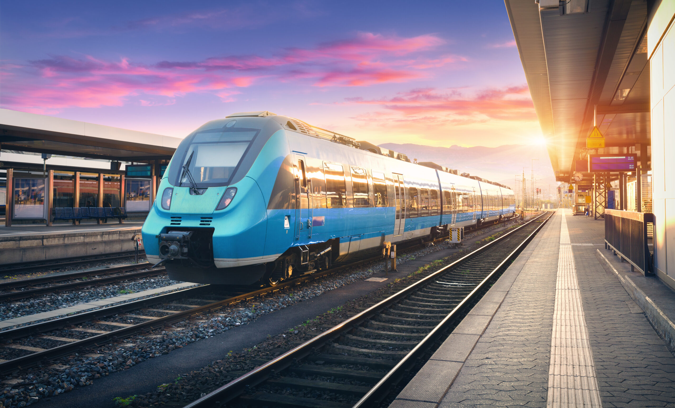 Modern high speed commuter train on the railway station Modern train in evening light