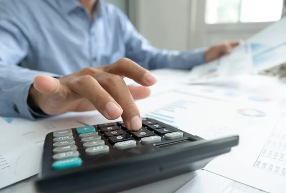 Man inputting tax return on calculator